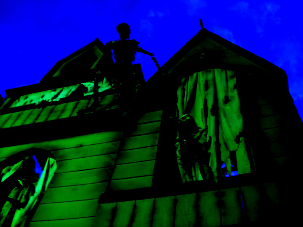 A spooky mansion, lit in green, looms ominously.