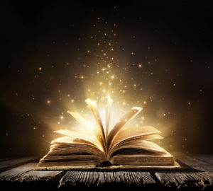 An open book against a dark background, light spilling from within