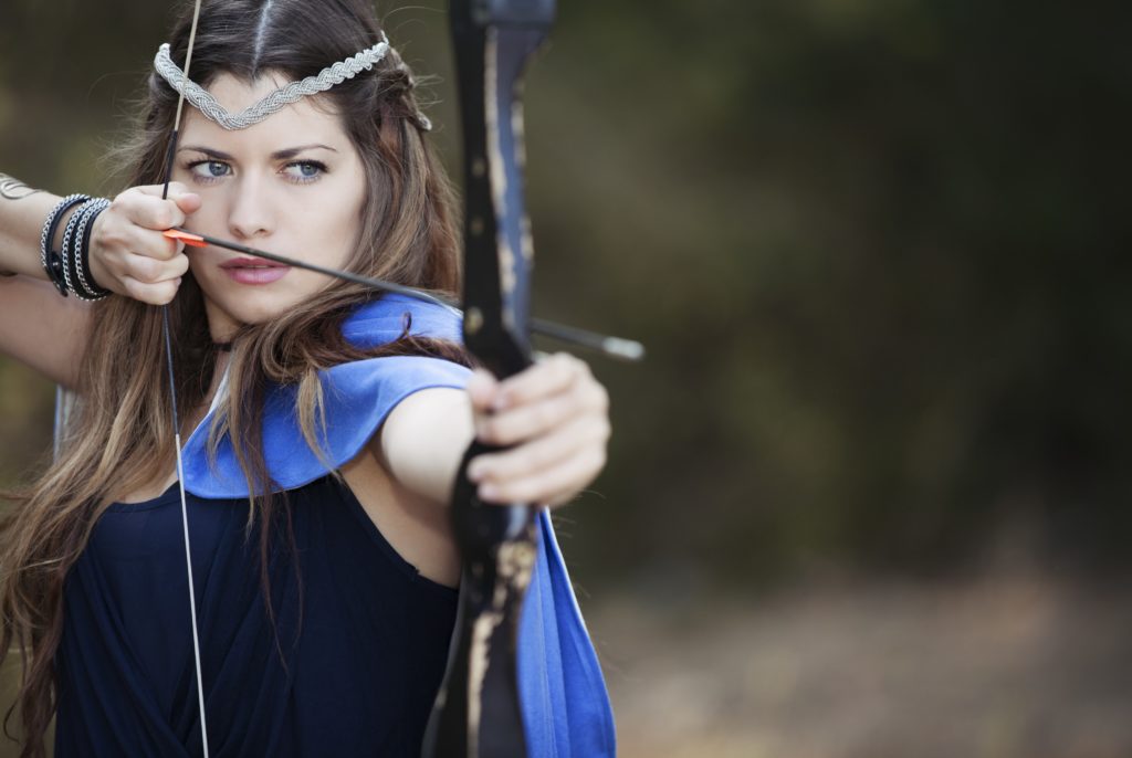 A woman with a circlet holds a bow in the drawn position.