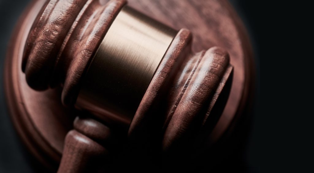 An auctioneer's gavel against a black background.