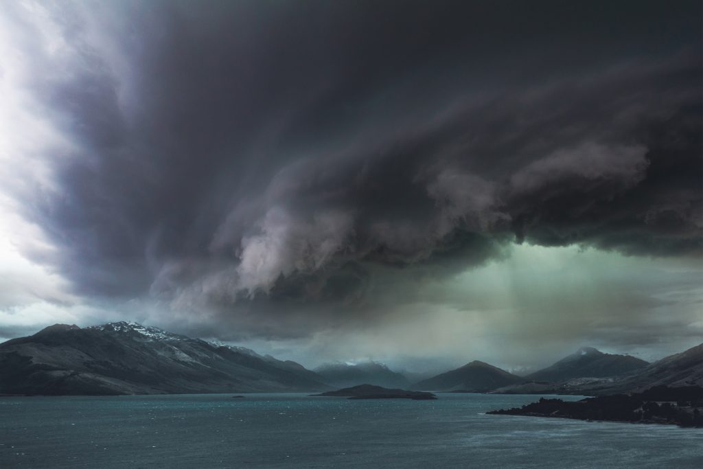 A dark storm gathers over a body of water