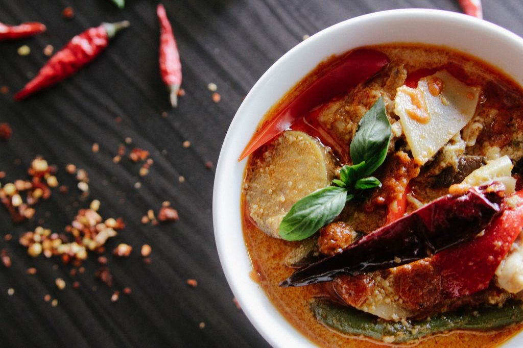 A kitchen table with a spicy stew upon it.