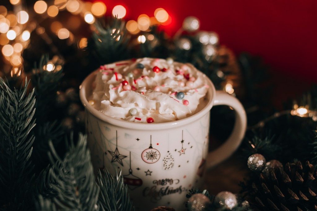 A mug of hot cocoa with whipped cream in a festive atmosphere
