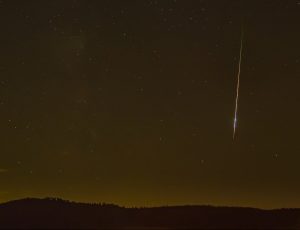 A shooting star against the night sky.
