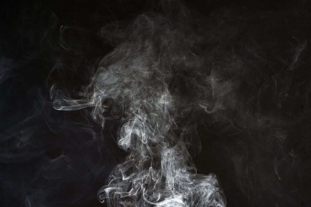 Pale grey smoke against a black background
