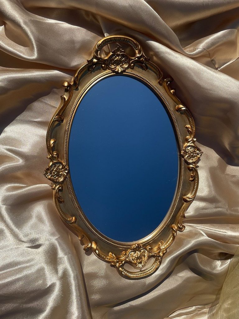 A mirror lies in the embrace of gold silk