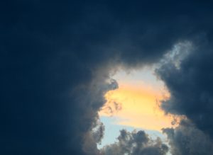 Dark clouds cover the sky in the picture, only a tiny strip of bright sky visible.