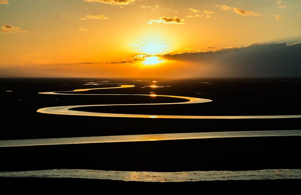 Sun rises over a meandering river.