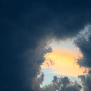 Dark clouds cover the sky in the picture, only a tiny strip of bright sky visible.