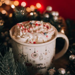 A mug of hot cocoa with whipped cream in a festive atmosphere