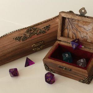 A handful of coloured dice sitting in a box.